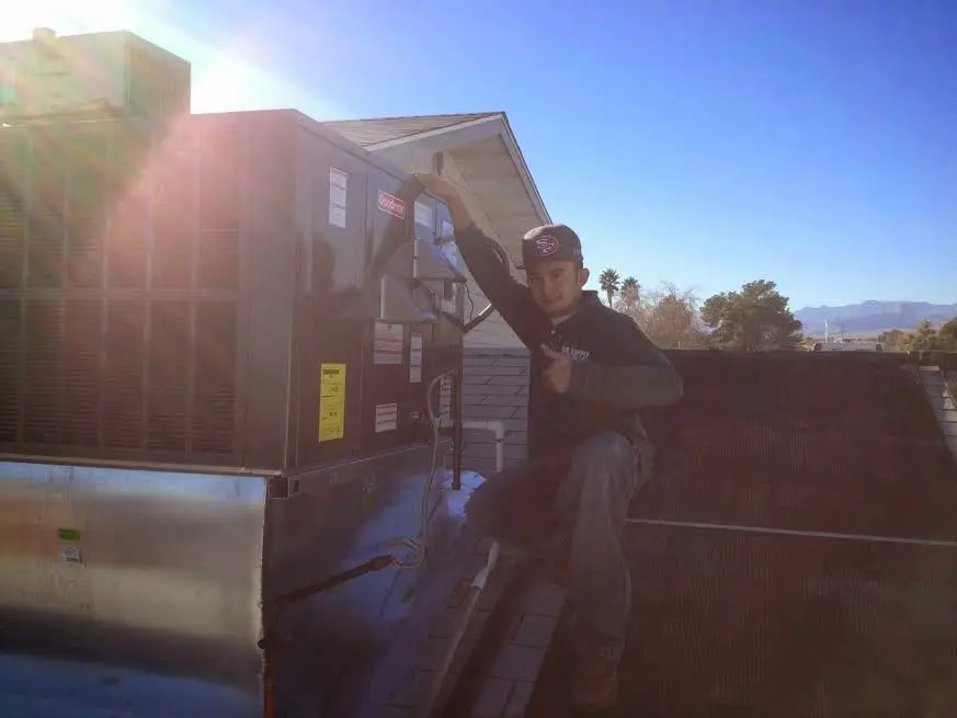 HVAC technician performing HVAC Inspection on a rooftop unit in Pascagoula